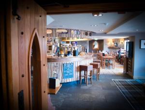 a bar in a restaurant with chairs and tables at The Inn on Loch Lomond in Luss