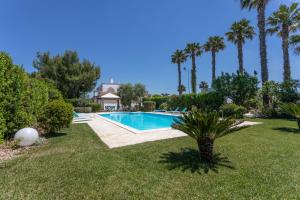 una piscina in un cortile con palme di Villa Pompea int. n ro 3 a Casarano