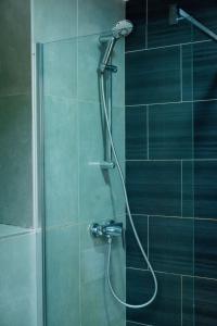 a shower with a shower head in a bathroom at Sultani Hotel in Kinshasa