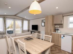 a kitchen and dining room with a wooden table and chairs at St Mawgan's Cove 1 in Newquay