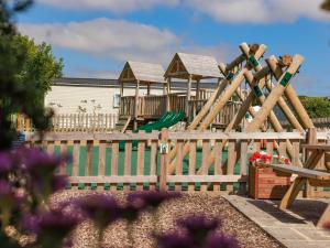a wooden fence with a playground in the background at St Mawgan's Cove 1 in Newquay