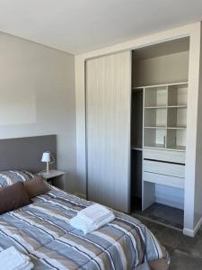 a bedroom with a bed and a piano in it at Frente a la playa, encantador departamento en PB in Puerto Madryn