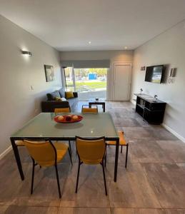 a living room with a green table and chairs at Frente a la playa, encantador departamento en PB in Puerto Madryn