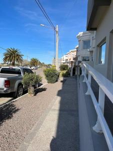 een auto geparkeerd aan de kant van een straat naast een gebouw bij Frente a la playa, encantador departamento en PB in Puerto Madryn