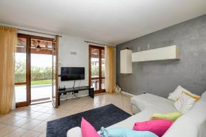 a living room with a white couch and a tv at Maison Elisa in Montinelle