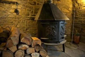 a stove in a room with a pile of logs at Worth House Bed and Breakfast in Wells