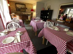 un restaurante con mesas y sillas de rayas rojas y blancas en Worth House Bed and Breakfast en Wells