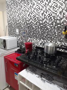 una cocina con una estufa roja con una olla. en Apartamento Temporada Dalva Copacabana 2, en Río de Janeiro