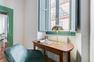a desk with a lamp and a chair in a room at The Unique Home Pantheon in Rome +58 photos