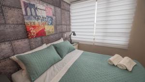 a bedroom with a bed with two towels on it at Departamento Temuco Centro in Temuco
