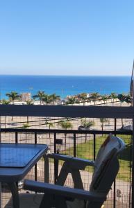 una mesa y una silla en un balcón con vistas a la playa en StarStudio, en Torremolinos