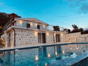 a large swimming pool in front of a house at Bezirgan Inn Kalkan in Islamlar
