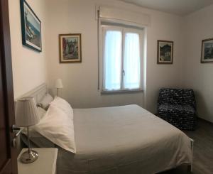 a bedroom with a white bed and a window at HOST IN LEVANTO - Maestrale con biciclette in Levanto