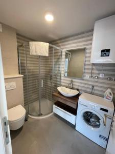 a bathroom with a toilet a sink and a washing machine at Villa Omazic in Trogir