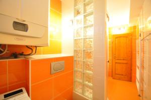 una piccola cucina con piastrelle arancioni e una porta di Rodinný dom "Ako doma" a Veľký Slavkov