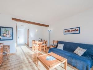 Una sala de estar con un sofá azul y una mesa. en Holiday Home Bonporteau-3 by Interhome, en Cavalaire-sur-Mer