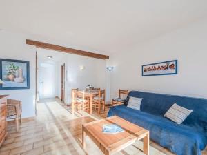 a living room with a blue couch and a table at Holiday Home Bonporteau-3 by Interhome in Cavalaire-sur-Mer