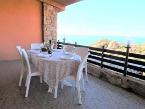 una mesa y sillas en un balcón con vistas al océano en Villa Gatti by Interhome, en Costa Paradiso