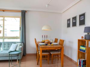 een eetkamer met een tafel en een blauwe bank bij Apartment Medina del Sol I-1 by Interhome in Denia