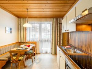 a kitchen with a table and a dining room at Apartment Vorreiter - UTD150 by Interhome in Uttendorf