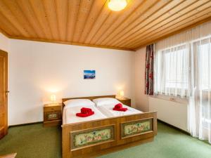 a bedroom with a bed with red pillows on it at Apartment Vorreiter - UTD150 by Interhome in Uttendorf