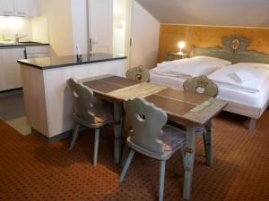 1 dormitorio con 1 cama, mesa de madera y sillas en Apartment Chalet Schwendihus-11 by Interhome, en Grindelwald