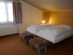 una camera d'albergo con due letti e una finestra di Apartment Chalet Schwendihus-11 by Interhome a Grindelwald