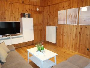 een woonkamer met een televisie en een tafel bij Chalet Martin by Interhome in Otterndorf