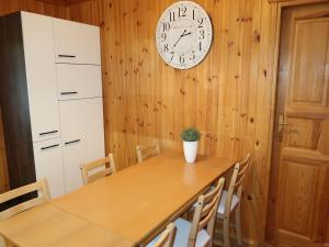 een eetkamer met een tafel en een klok aan de muur bij Chalet Martin by Interhome in Otterndorf