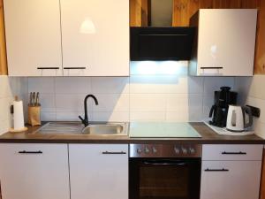 een keuken met witte kasten en een spoelbak bij Chalet Martin by Interhome in Otterndorf +14 foto's