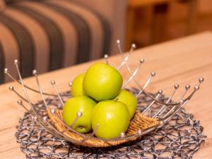 una cesta de manzanas verdes sobre una mesa de madera en Apartment Am Nordkap-1 by Interhome en Norddeich