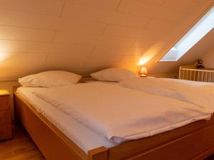 1 cama con sábanas blancas y almohadas en una habitación en Apartment Am Nordkap-1 by Interhome en Norddeich