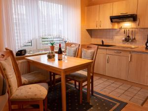 una cocina con mesa y sillas y una botella de vino en Apartment Am Nordkap-1 by Interhome en Norddeich
