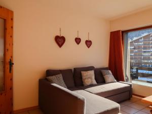un soggiorno con divano e cuori appesi al muro di Apartment Christiania 2 C8 by Interhome a Nendaz