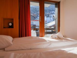 un letto in una camera con una grande finestra di Apartment Christiania 2 C8 by Interhome a Nendaz
