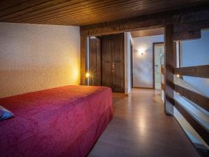 a bedroom with a pink bed in a room at Apartment Jorasse C 20 by Interhome in Ovronnaz