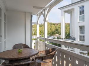 a balcony with a wooden table and chairs and a window at Apartment Seepark Sellin-4 by Interhome in Ostseebad Sellin