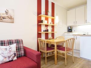 a living room with a table and chairs and a kitchen at Apartment Seepark Sellin-2 by Interhome in Ostseebad Sellin
