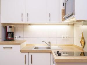 a kitchen with white cabinets and a sink at Apartment Seepark Sellin-2 by Interhome in Ostseebad Sellin