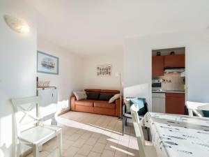a living room with a couch and a kitchen at Apartment Les Jardins del Mar-2 by Interhome in Cavalaire-sur-Mer