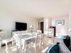 ein Wohnzimmer mit einem weißen Tisch und Stühlen in der Unterkunft Apartment Les Jardins del Mar-2 by Interhome in Cavalaire-sur-Mer