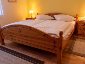 ノルトダイヒにあるApartment Am Nordkap-2 by Interhomeのベッドルーム1室(白いシーツと枕が備わる木製ベッド1台付)