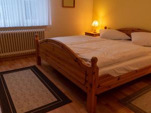 ノルトダイヒにあるApartment Am Nordkap-2 by Interhomeのベッドルーム1室(白いシーツを使用した大きな木製ベッド1台付)