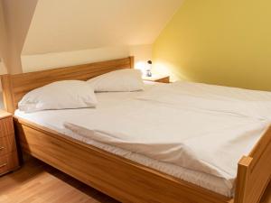 ノルトダイヒにあるApartment Am Nordkap-4 by Interhomeのベッドルーム1室(大型ベッド1台、白いシーツ、枕付)