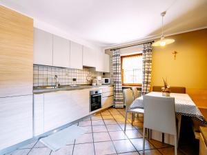 a kitchen with a table and a dining room at Apartment Carmen-4 by Interhome in Soraga