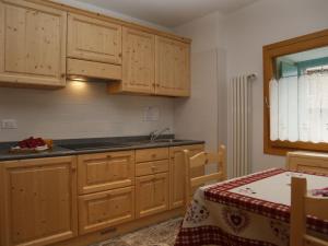 a kitchen with wooden cabinets and a sink and a table at Apartment Cjase Fravins-2 by Interhome in Raveo