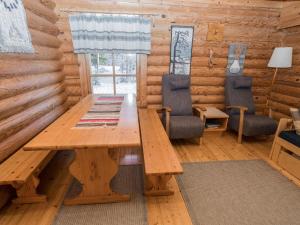 a wooden table and chairs in a log cabin at Holiday Home Ruka-kitkan lomamajat-varpunen by Interhome in Säkkilänvaara