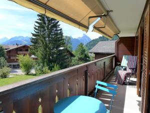 a balcony with chairs and a view of mountains at Apartment Monique Nr- 9 by Interhome in Gstaad