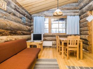 comedor con mesa y TV en una cabina en Holiday Home Kuontijärvi b by Interhome, en Ruka