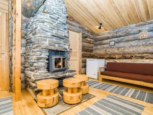 Cabaña de madera con sala de estar con chimenea de piedra. en Holiday Home Kuontijärvi b by Interhome, en Ruka